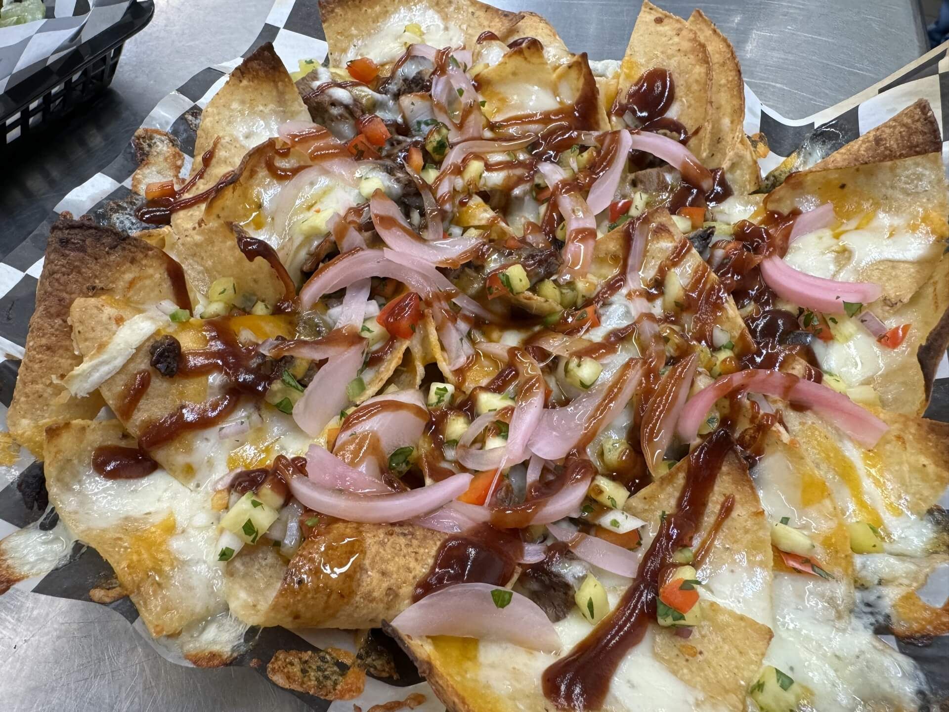 A close up of a plate of nachos on a table.