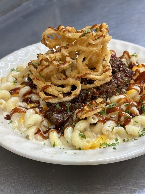 A white plate topped with macaroni and cheese and french fries.