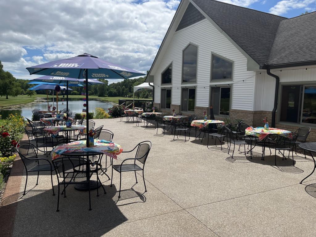 A patio with tables and chairs and umbrellas with the word budweiser on them