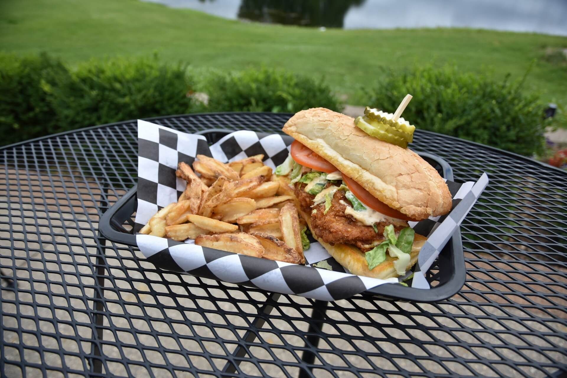 A sandwich and french fries are on a table.