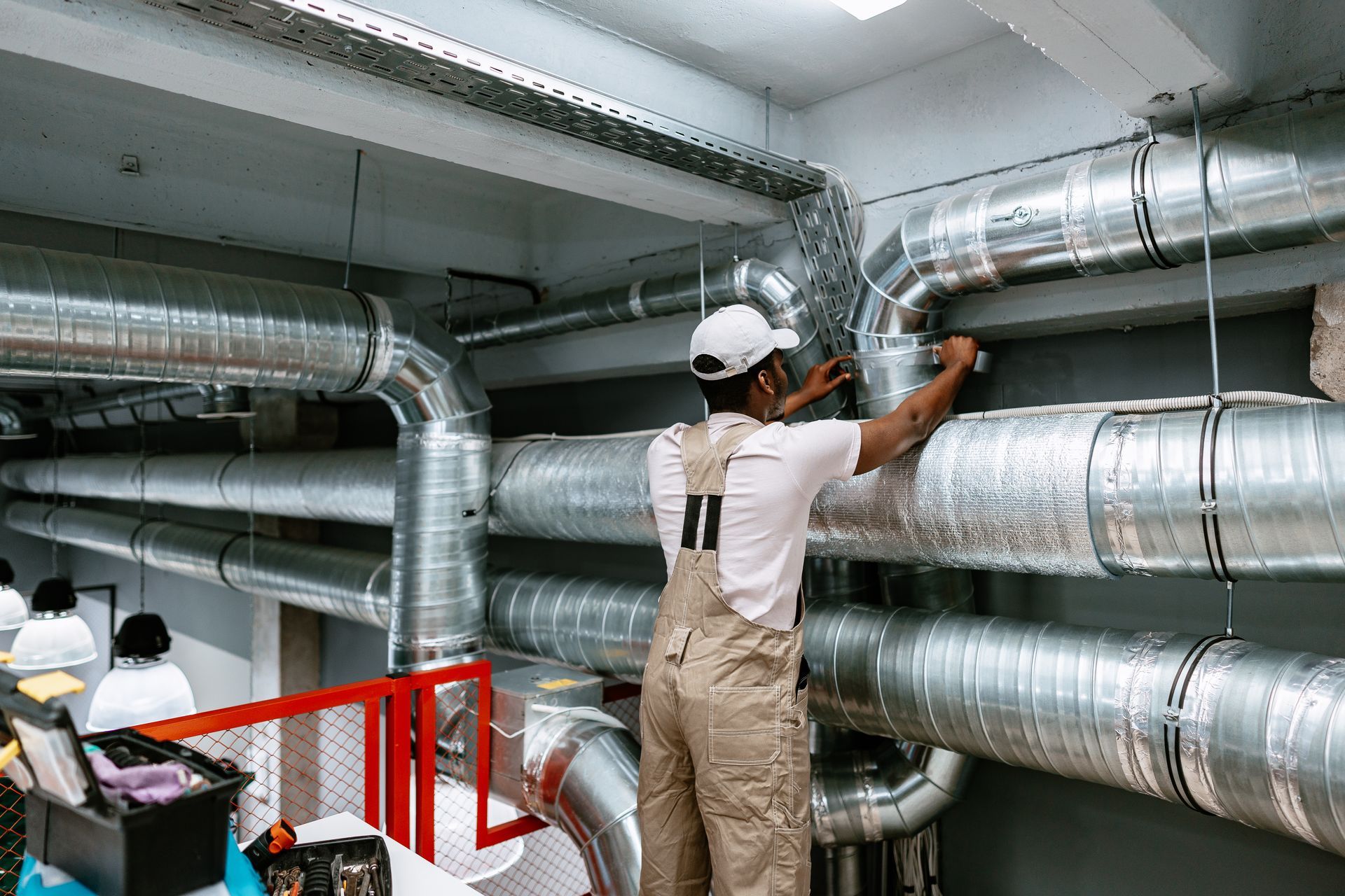 Person working on HVAC ductwork in a building.