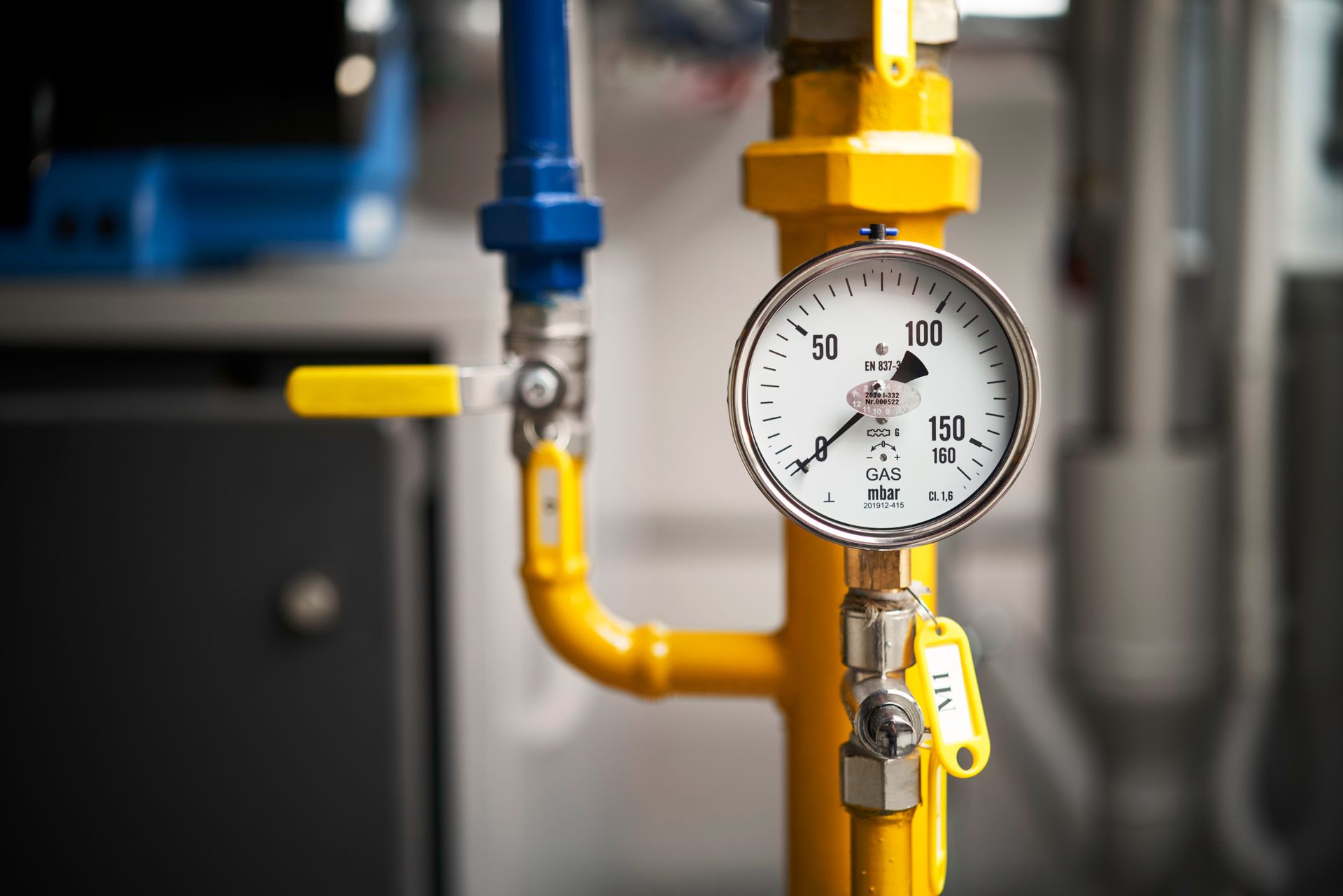 Yellow pipes with a pressure gauge, connected to a blue pipe and a yellow valve.