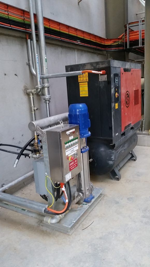 A large machine is sitting in a room next to a wall.