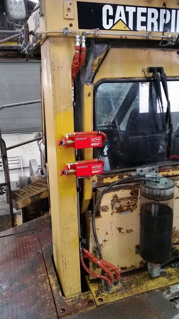 A yellow caterpillar truck is parked in a garage.