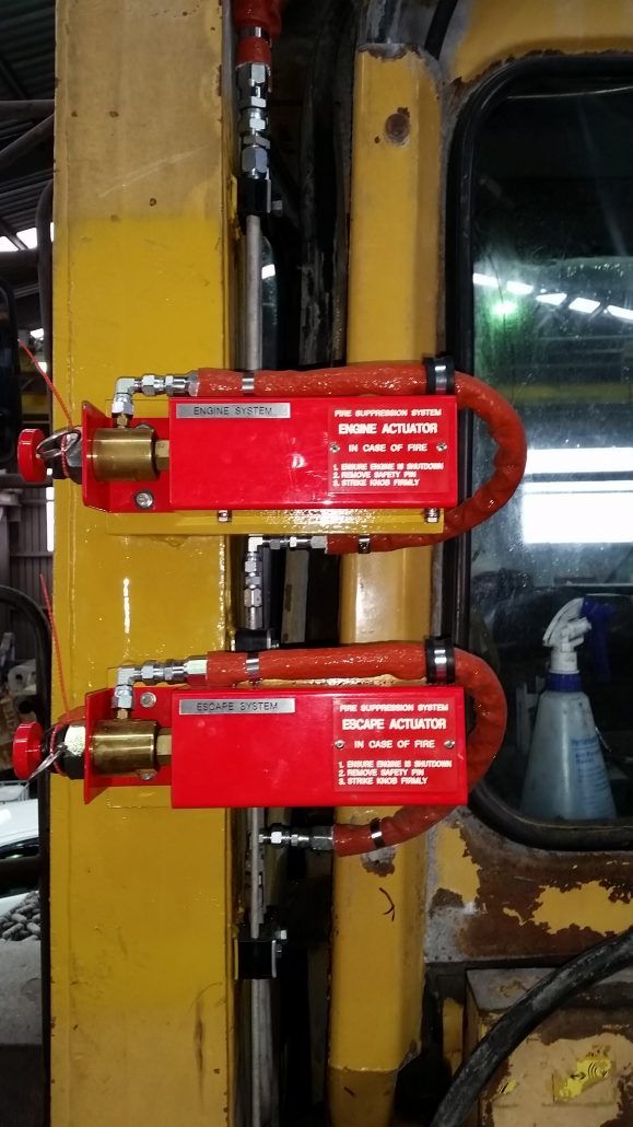 A yellow forklift with two red locks attached to it.