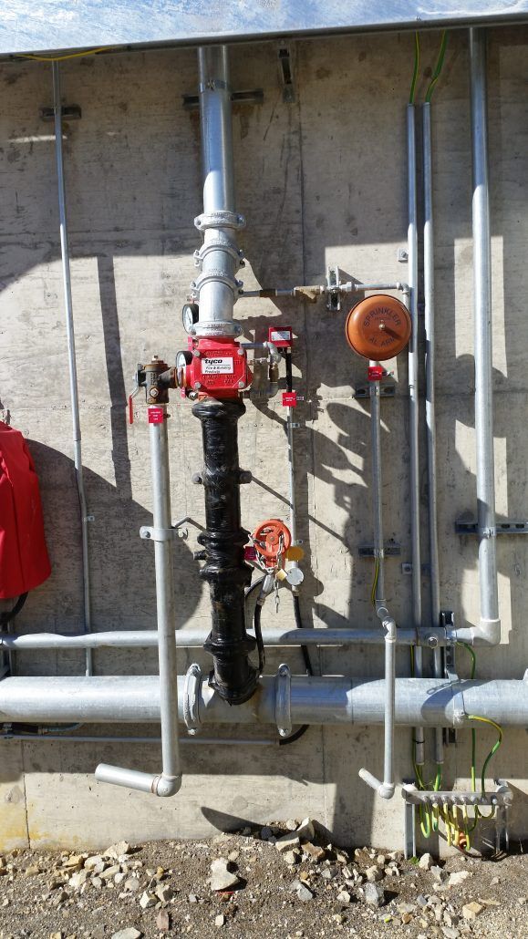 A bunch of pipes are connected to a wall.