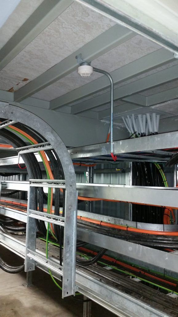 A bunch of wires are hanging from the ceiling of a building.