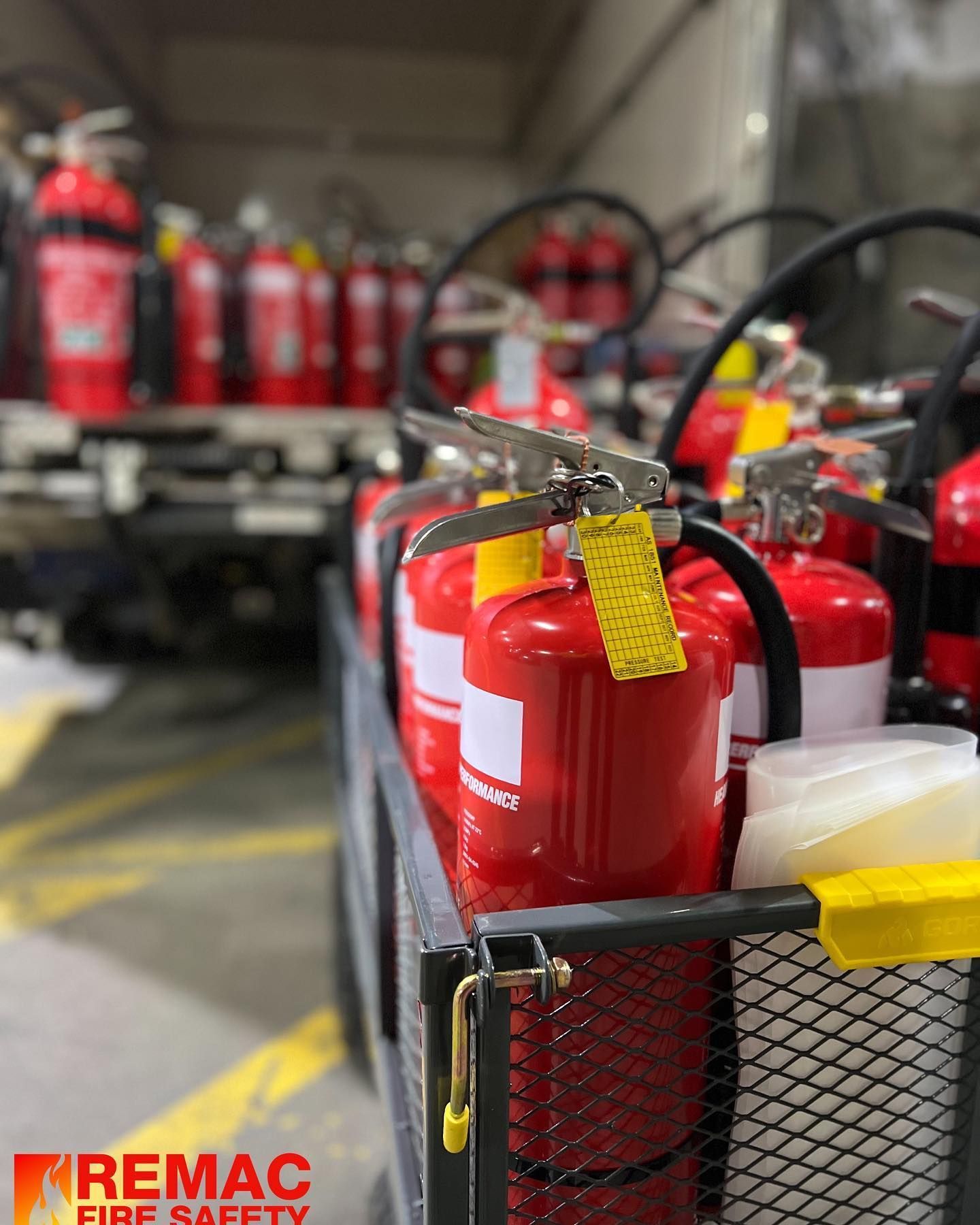 A bunch of red fire extinguishers are in a cart