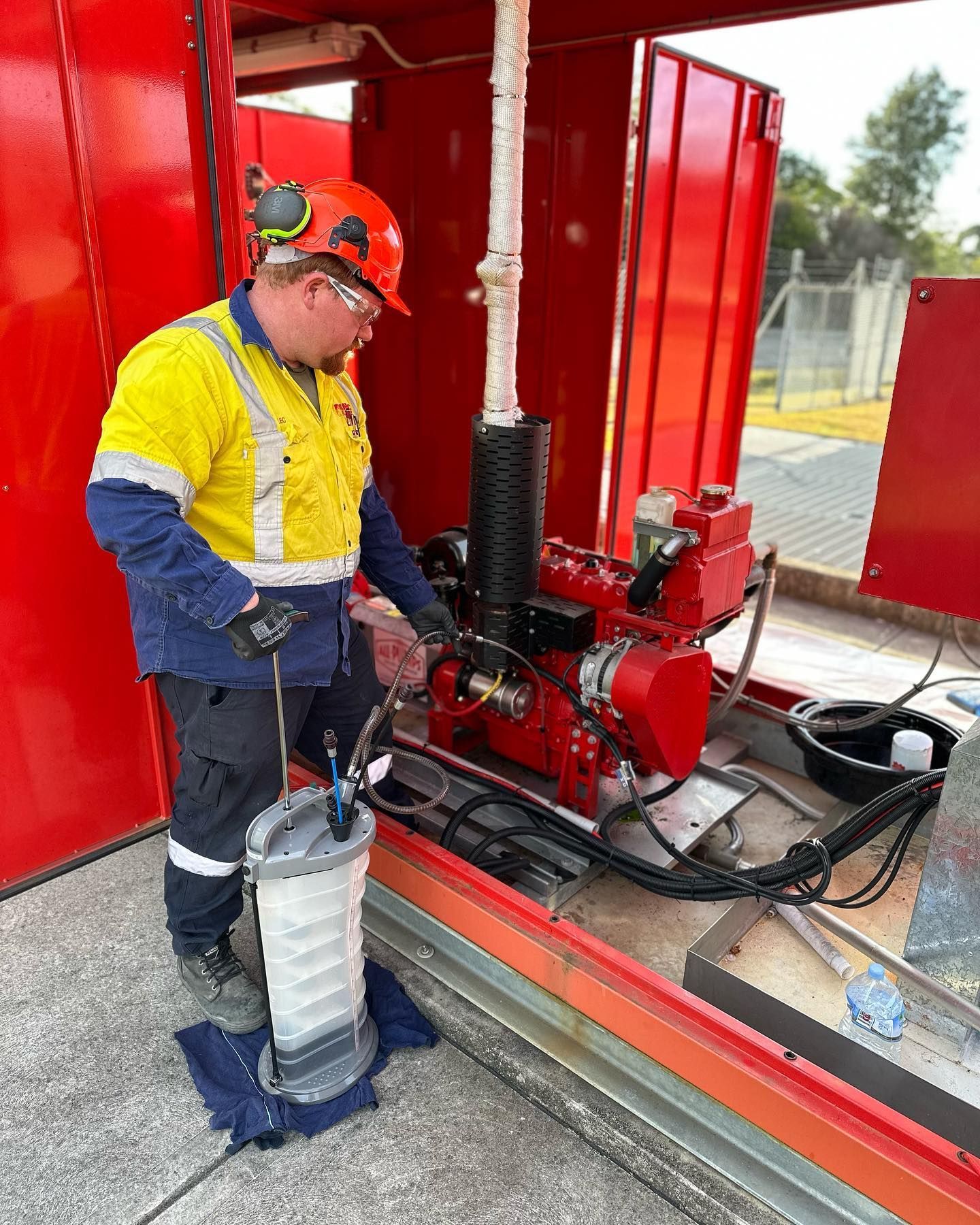 A man in a hard hat is working on a machine.