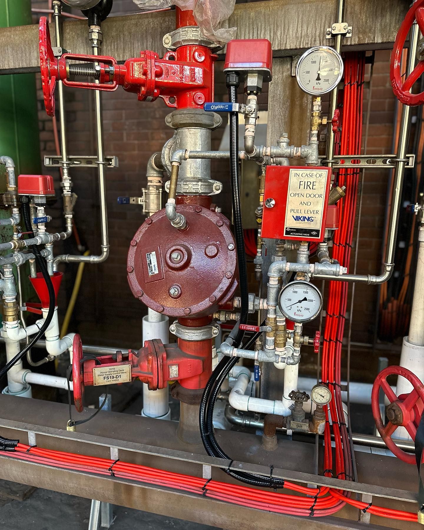 A bunch of pipes and valves in a room with a sign that says ' notice ' on it