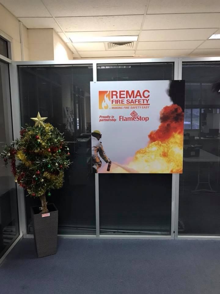 A christmas tree is in front of a sign that says remac fire safety