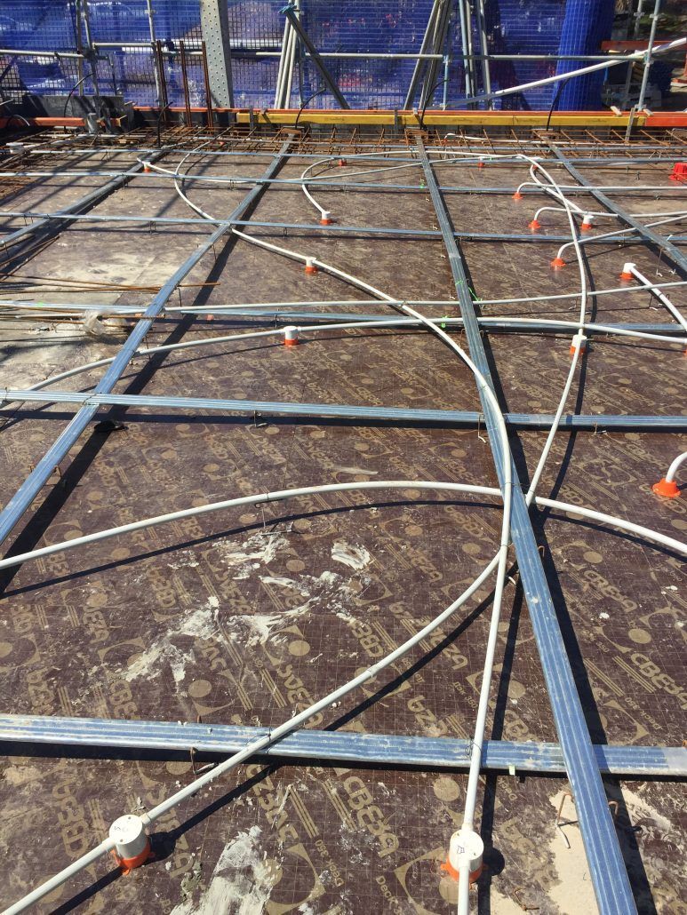 A bunch of wires are laying on the ground on a construction site.