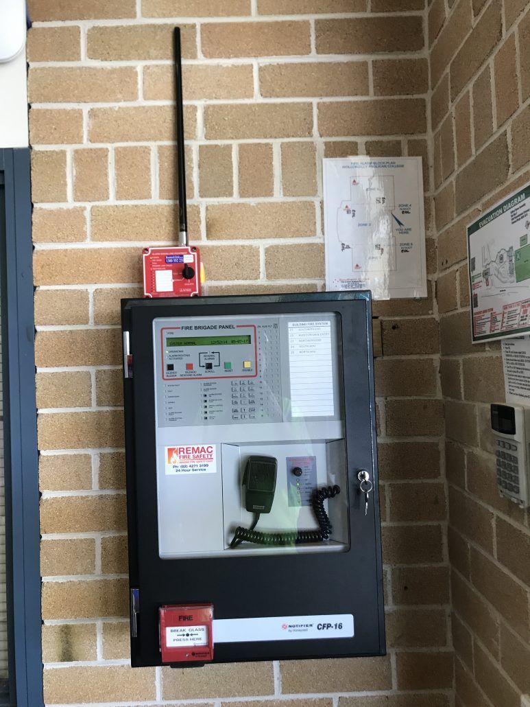 A fire alarm is mounted on a brick wall