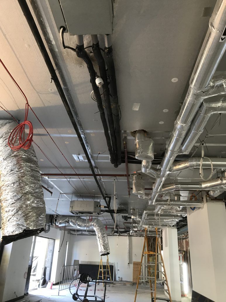 A room with a lot of pipes hanging from the ceiling.