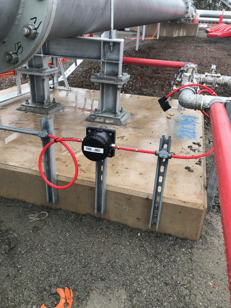 A close up of a pipe with a red wire attached to it.