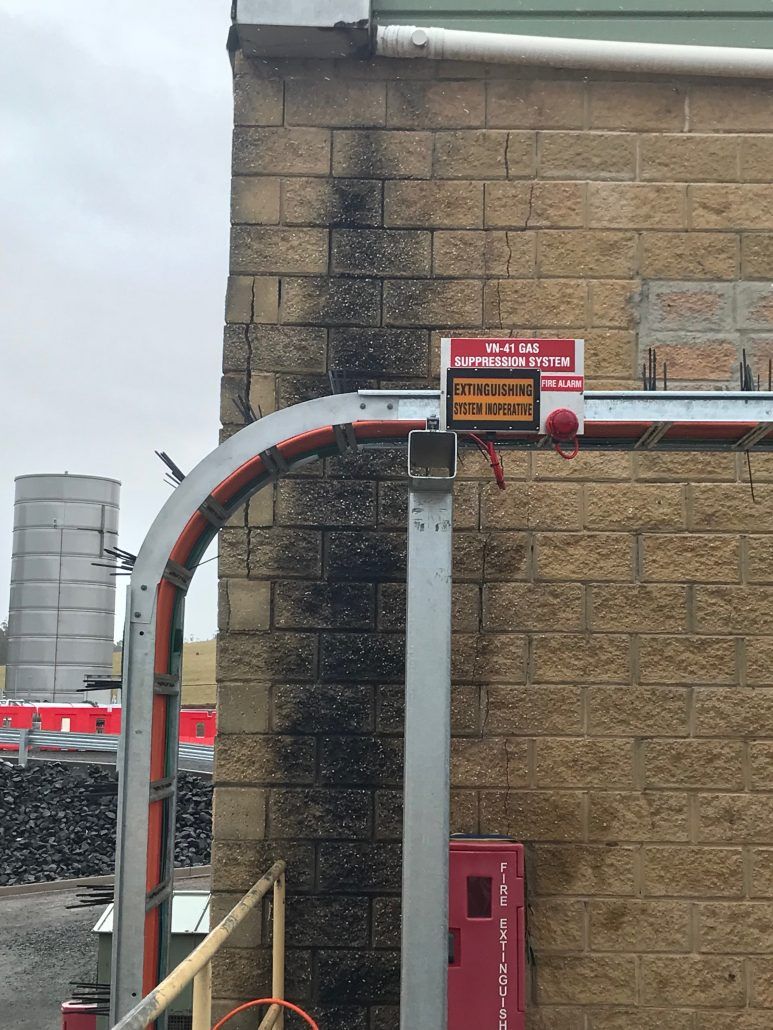 A brick building with a red box on the side of it.