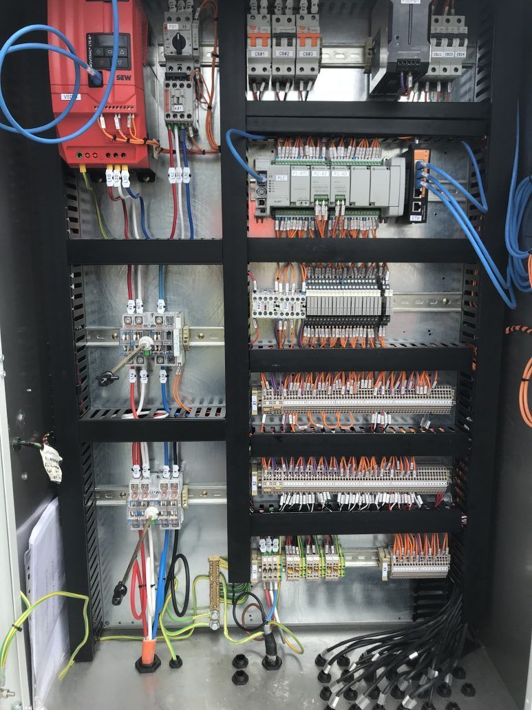 The inside of a control panel with a lot of wires
