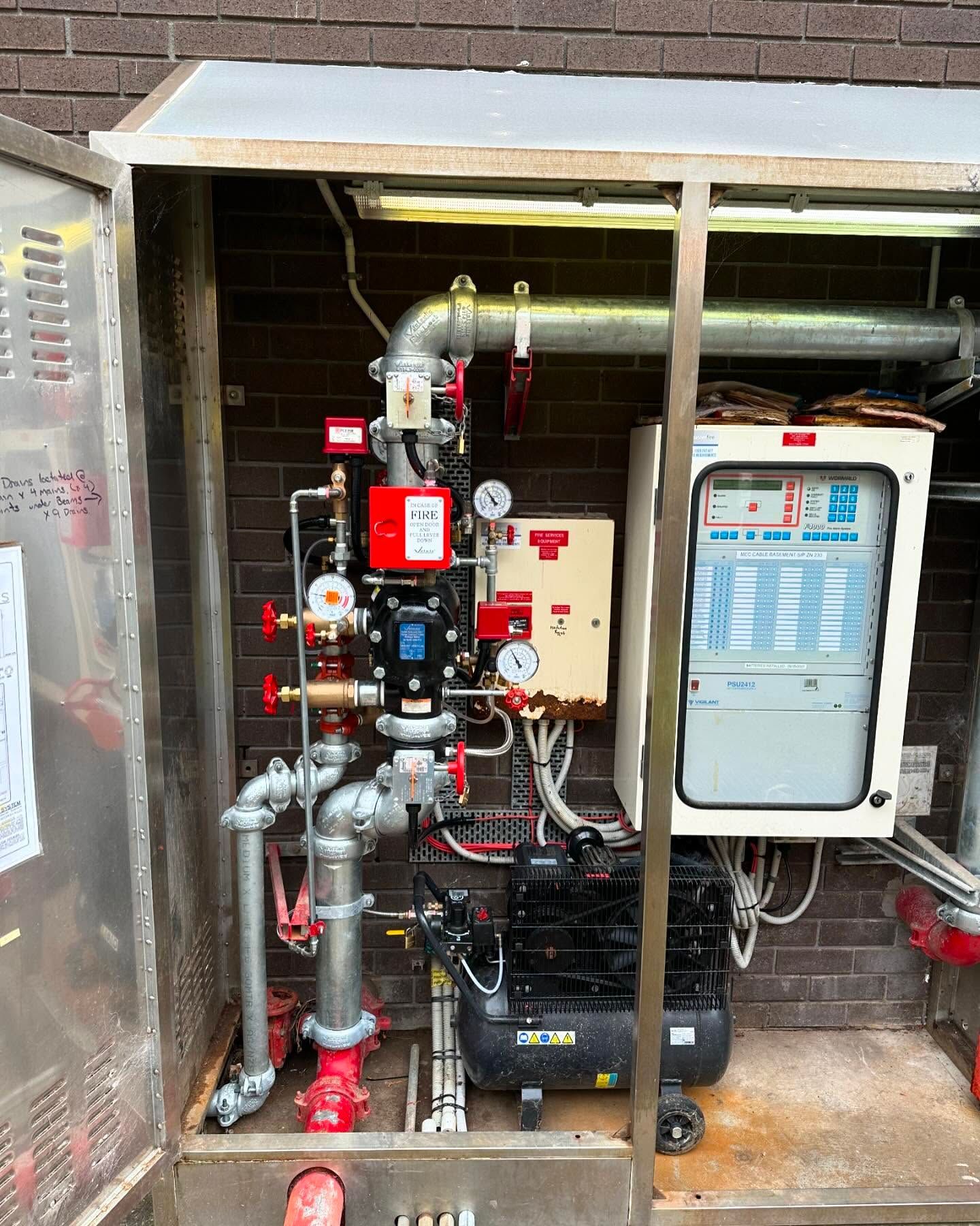 A stainless steel box with a lot of pipes inside of it