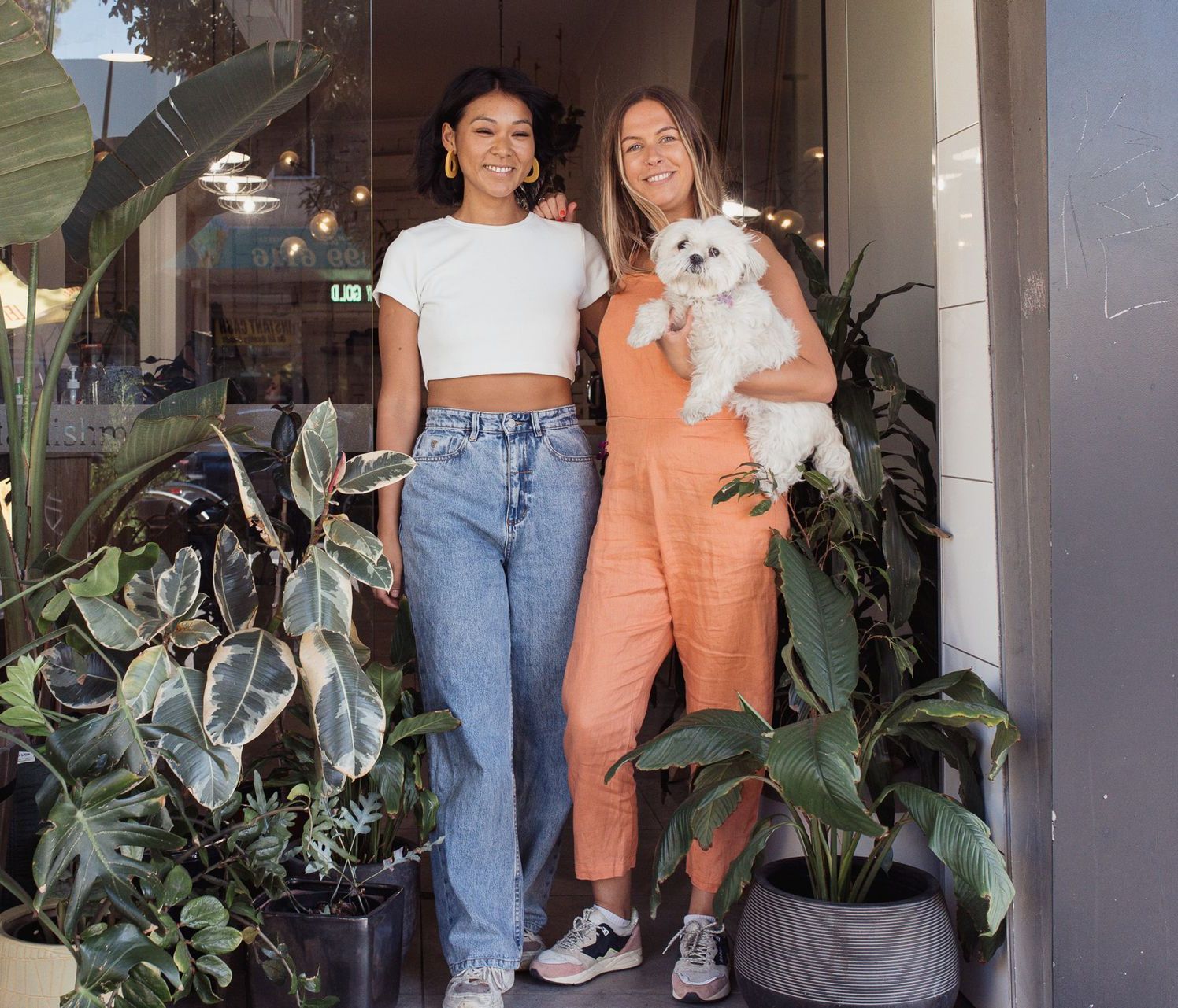 Two women are standing next to each other holding a dog.