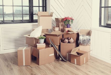 A room filled with cardboard boxes and a skateboard.