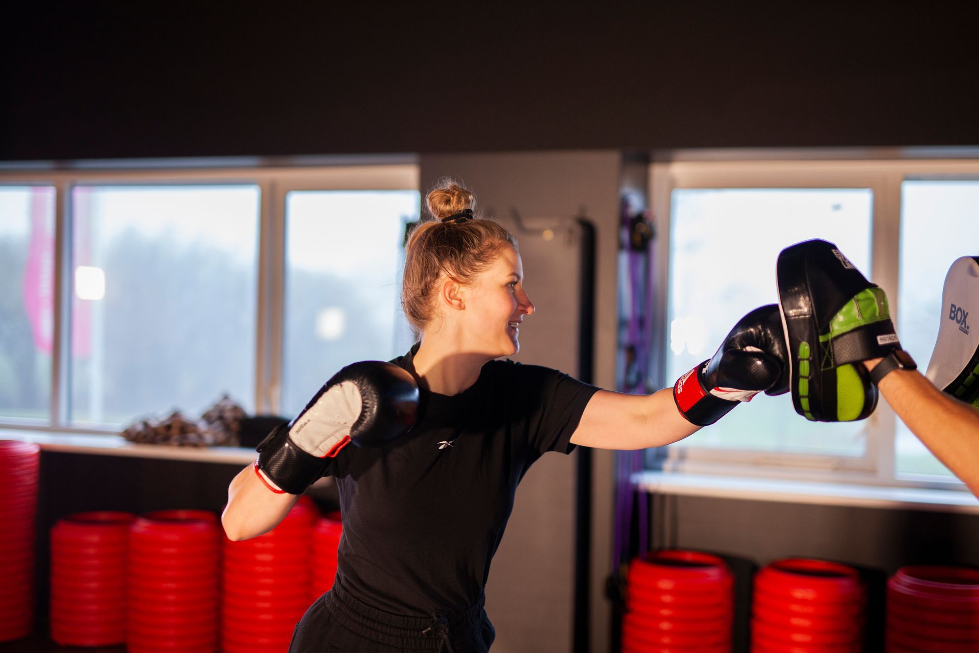 Een vrouw bokst met een man in de sportschool.