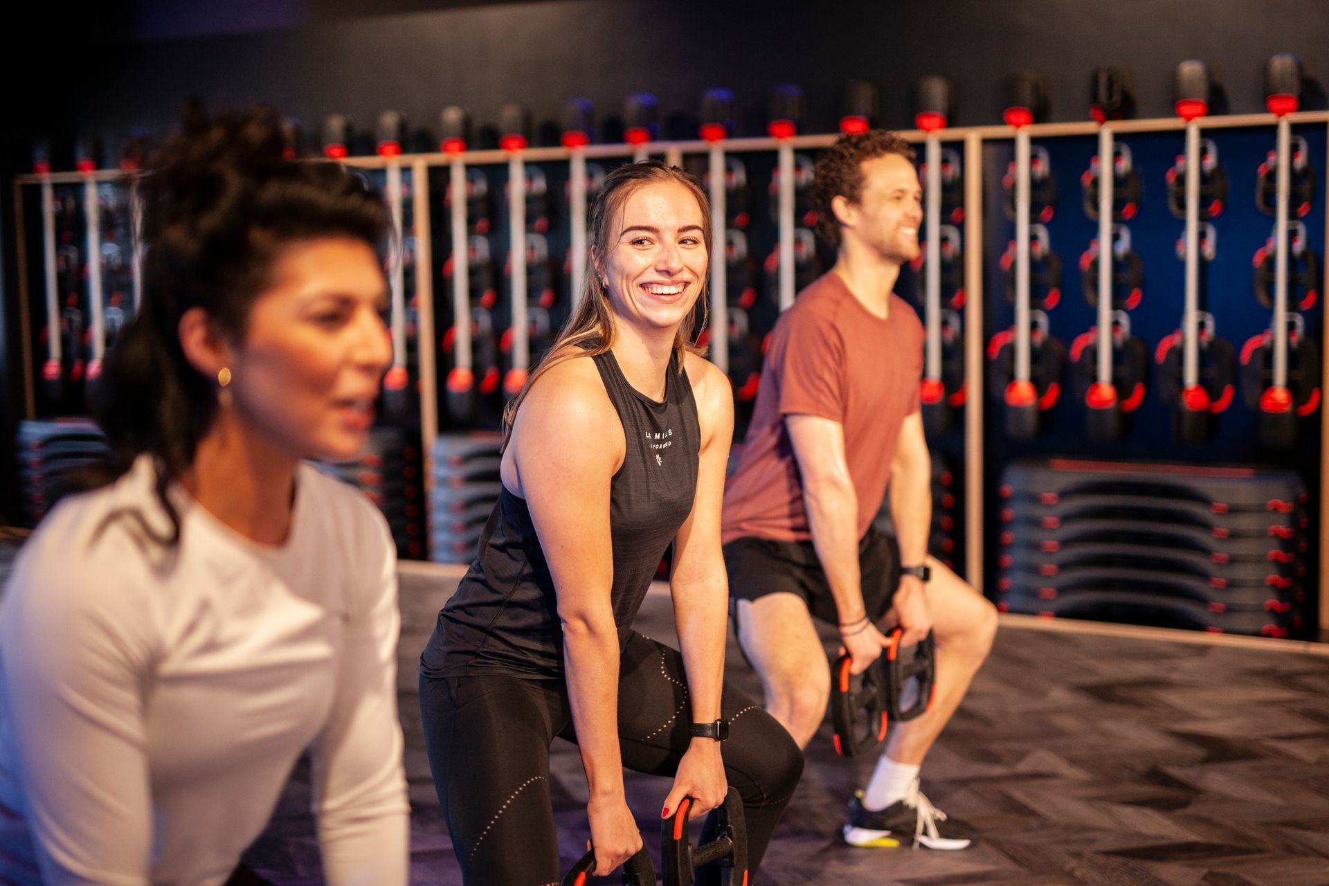 Een groep mensen staat in een sportschool met halters.