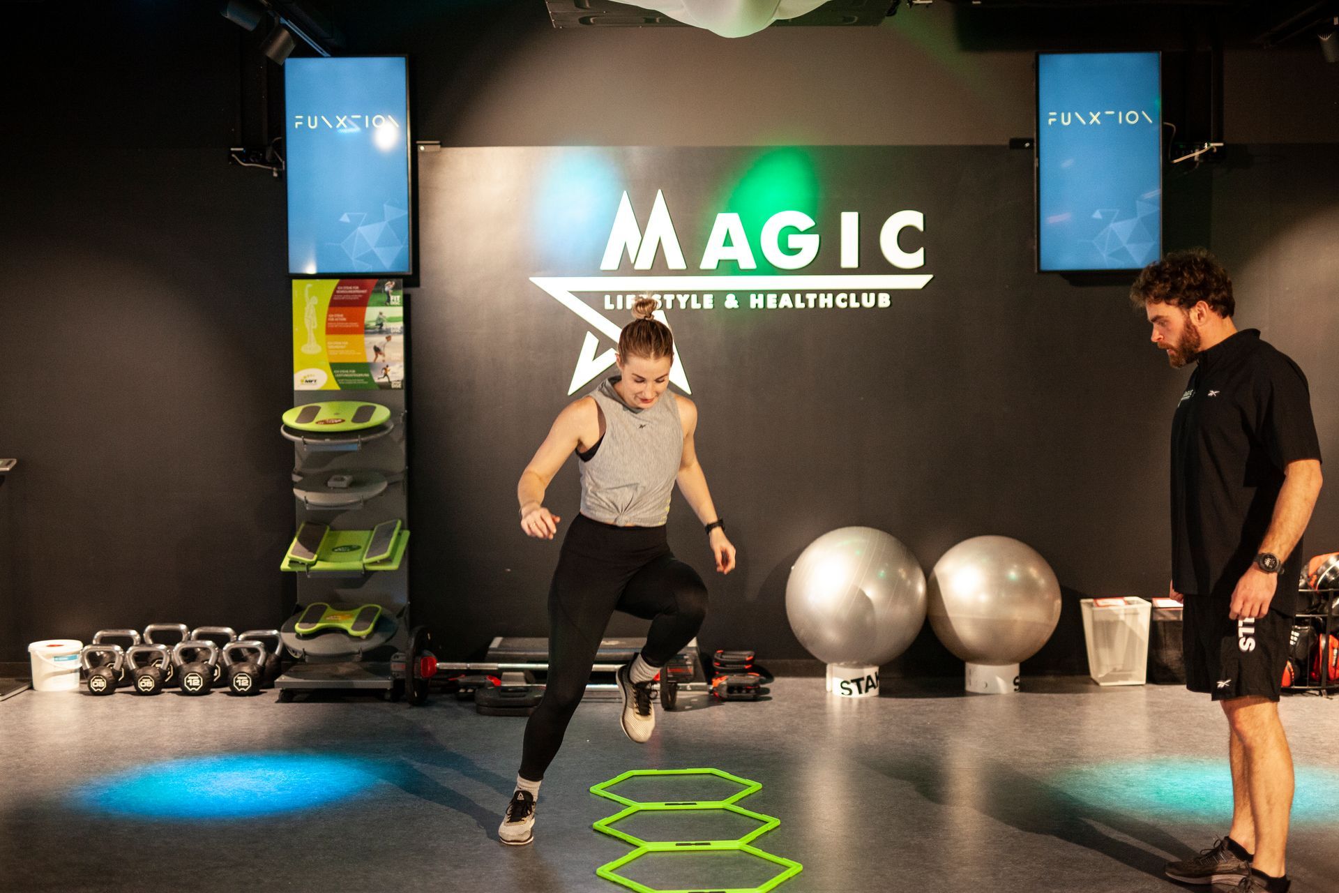 Een man springt in de lucht voor een bord met de tekst magie