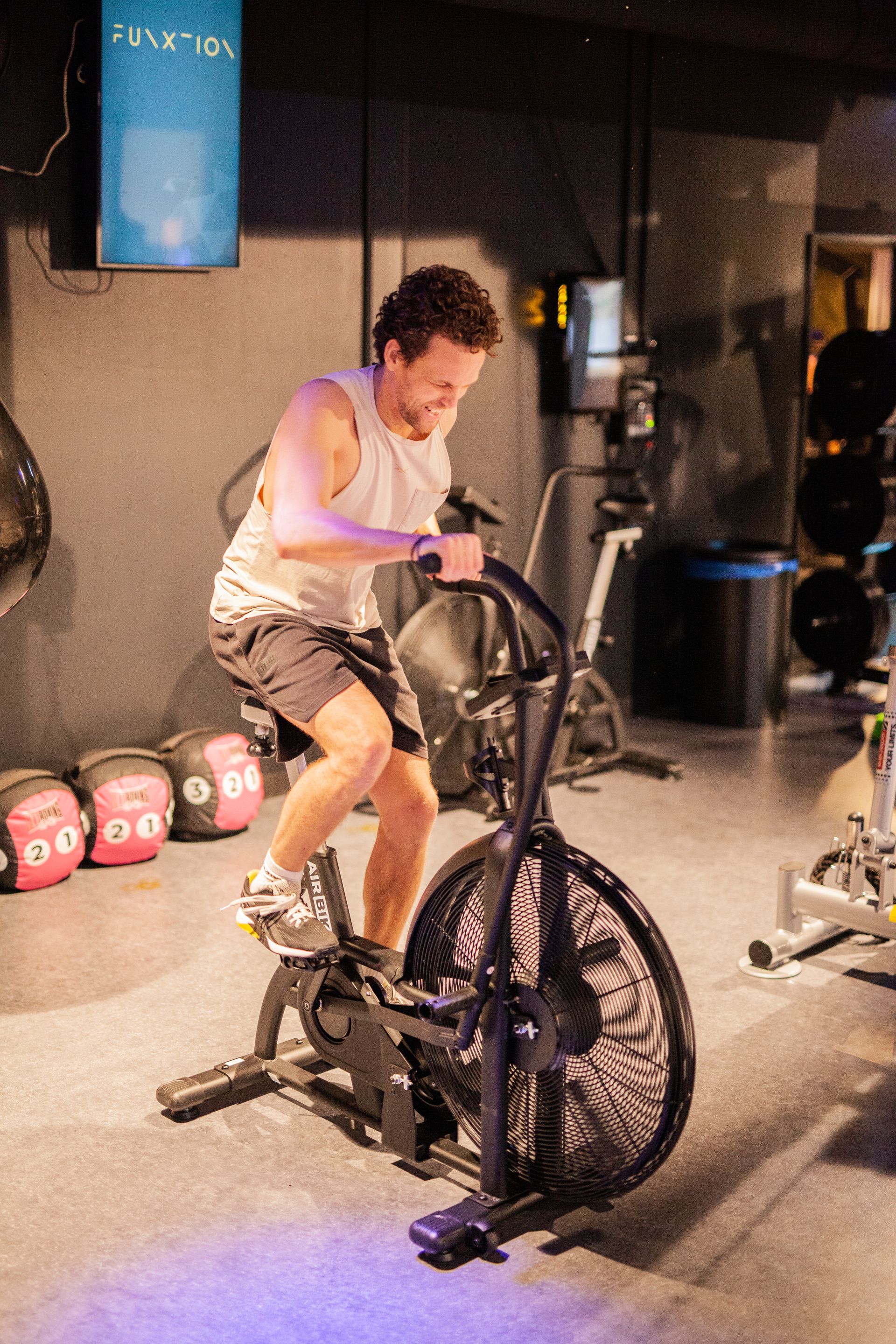 Een man fietst op een hometrainer in een sportschool.