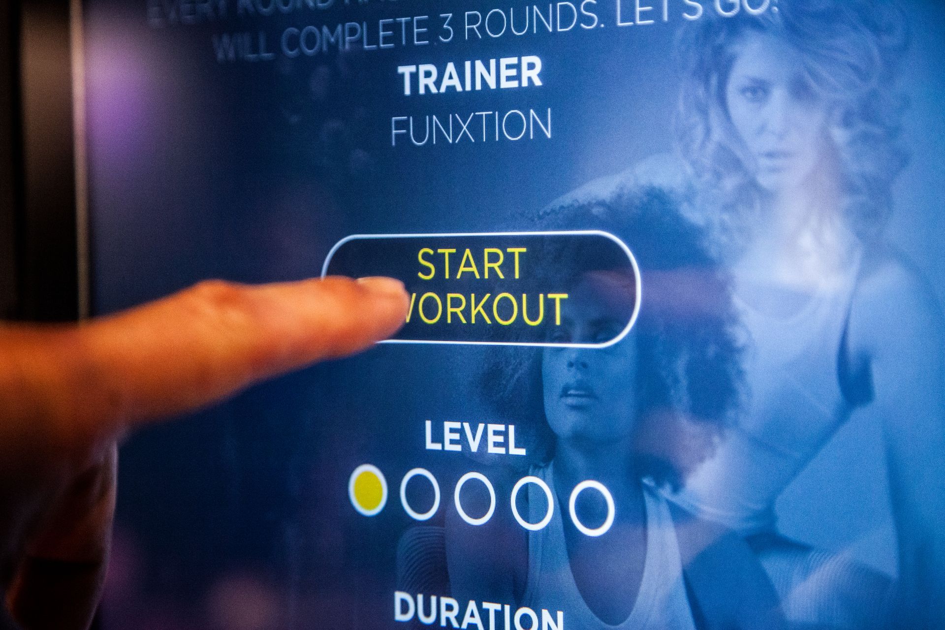 Een persoon wijst naar een startknop voor een training op een scherm.