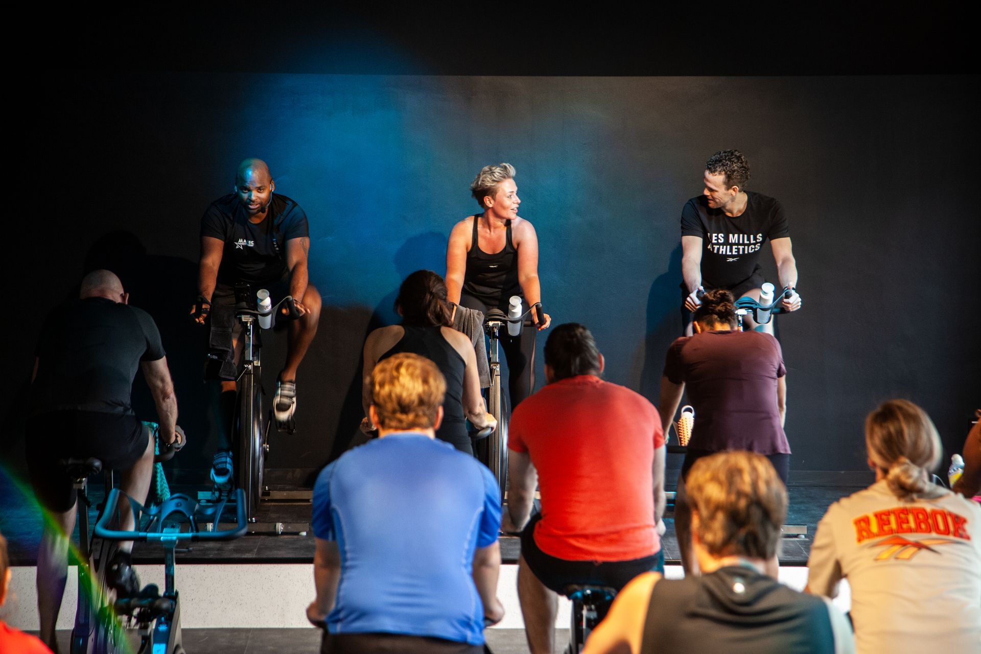 Een groep mensen fietst op een hometrainer in een sportschool.