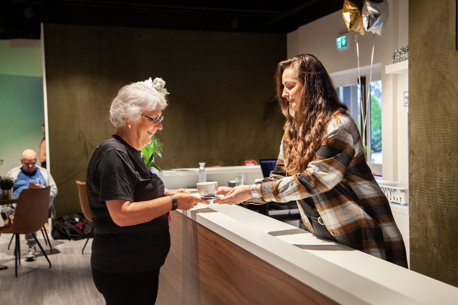 Twee vrouwen staan ​​aan een toonbank in een restaurant.