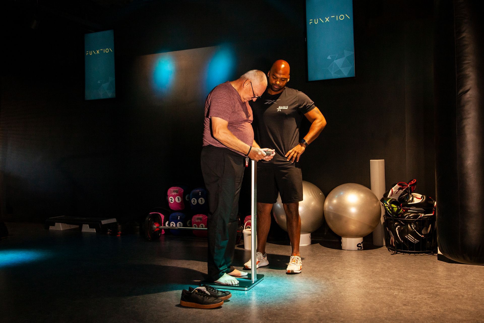 Twee mannen wegen elkaar in een sportschool.