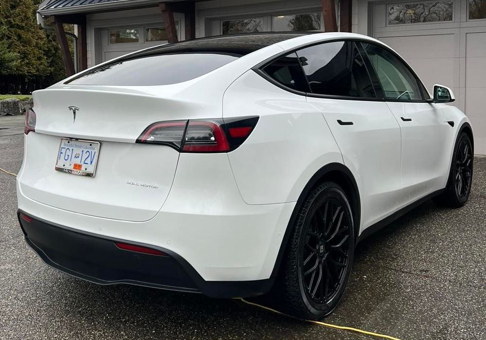 white Tesla car parked outside the garage