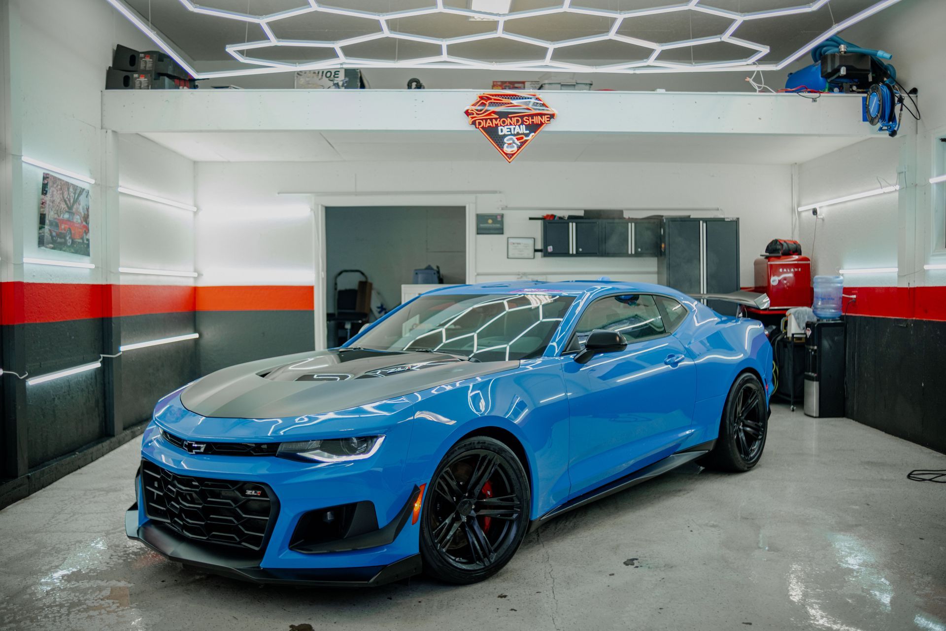 A person is cleaning a car with a blue sponge.