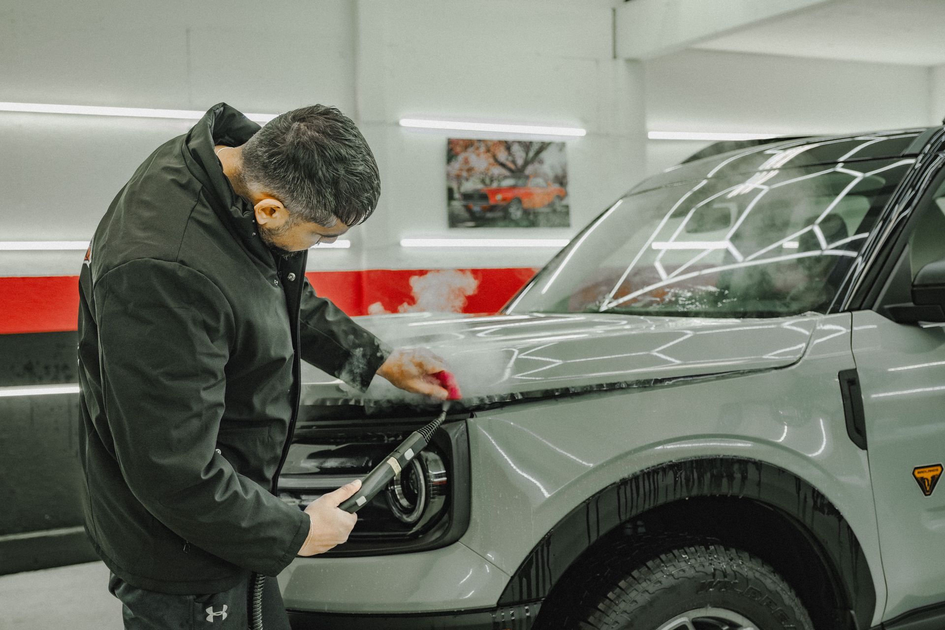 A car is being washed with foam in a garage.