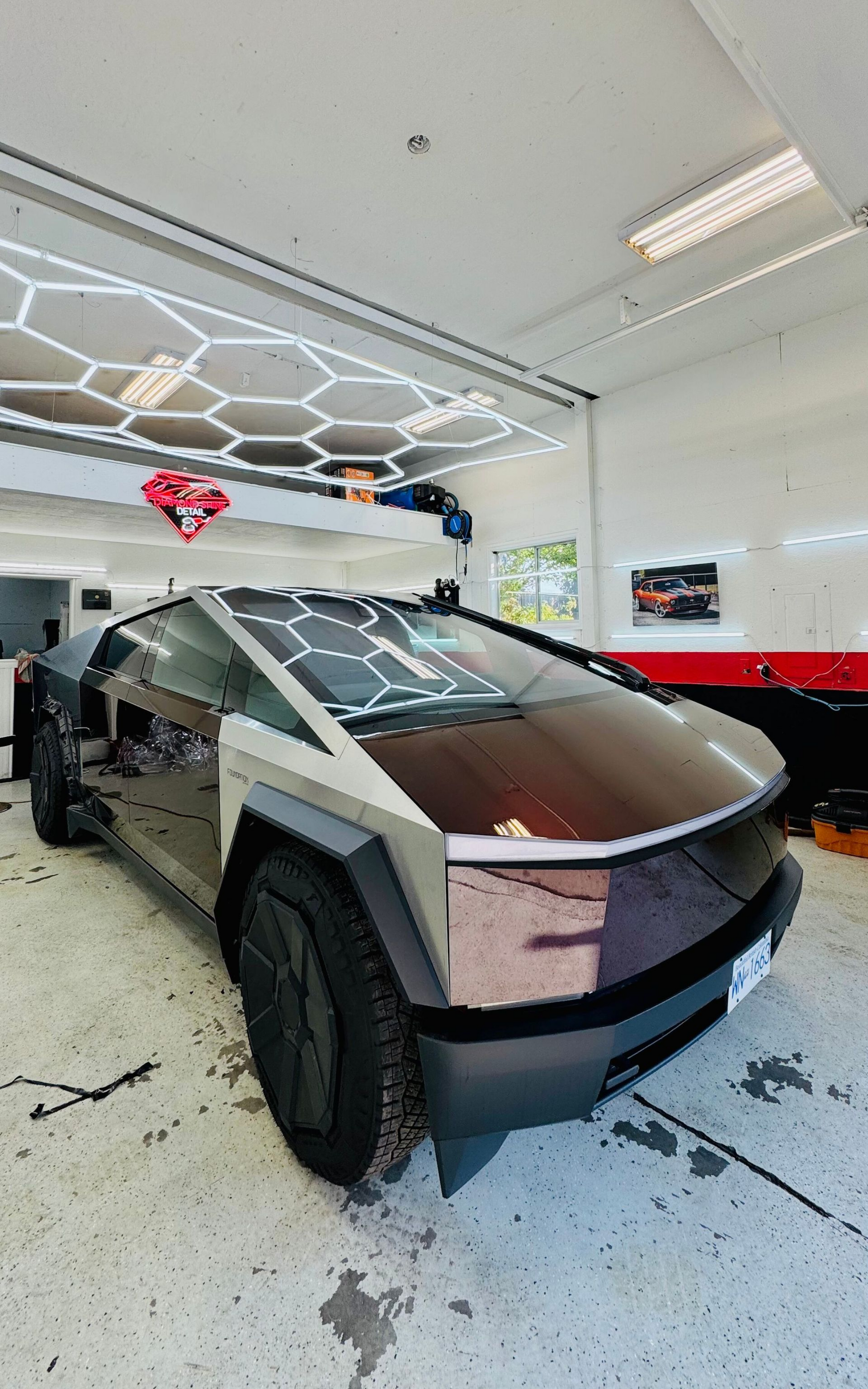 Tesla Cybertruck with a custom wrap in a garage setting.