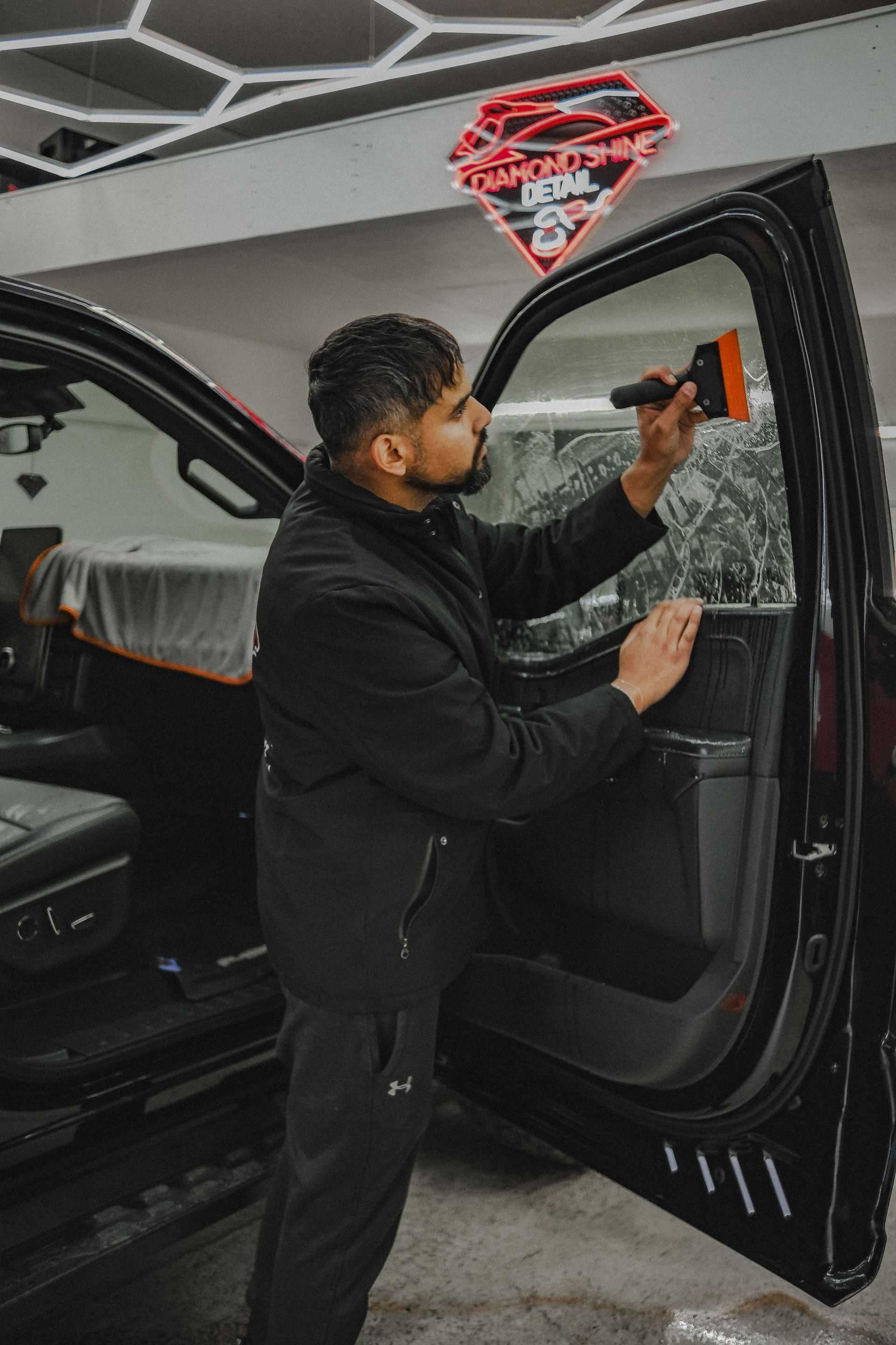 A car is being washed with foam in a garage.