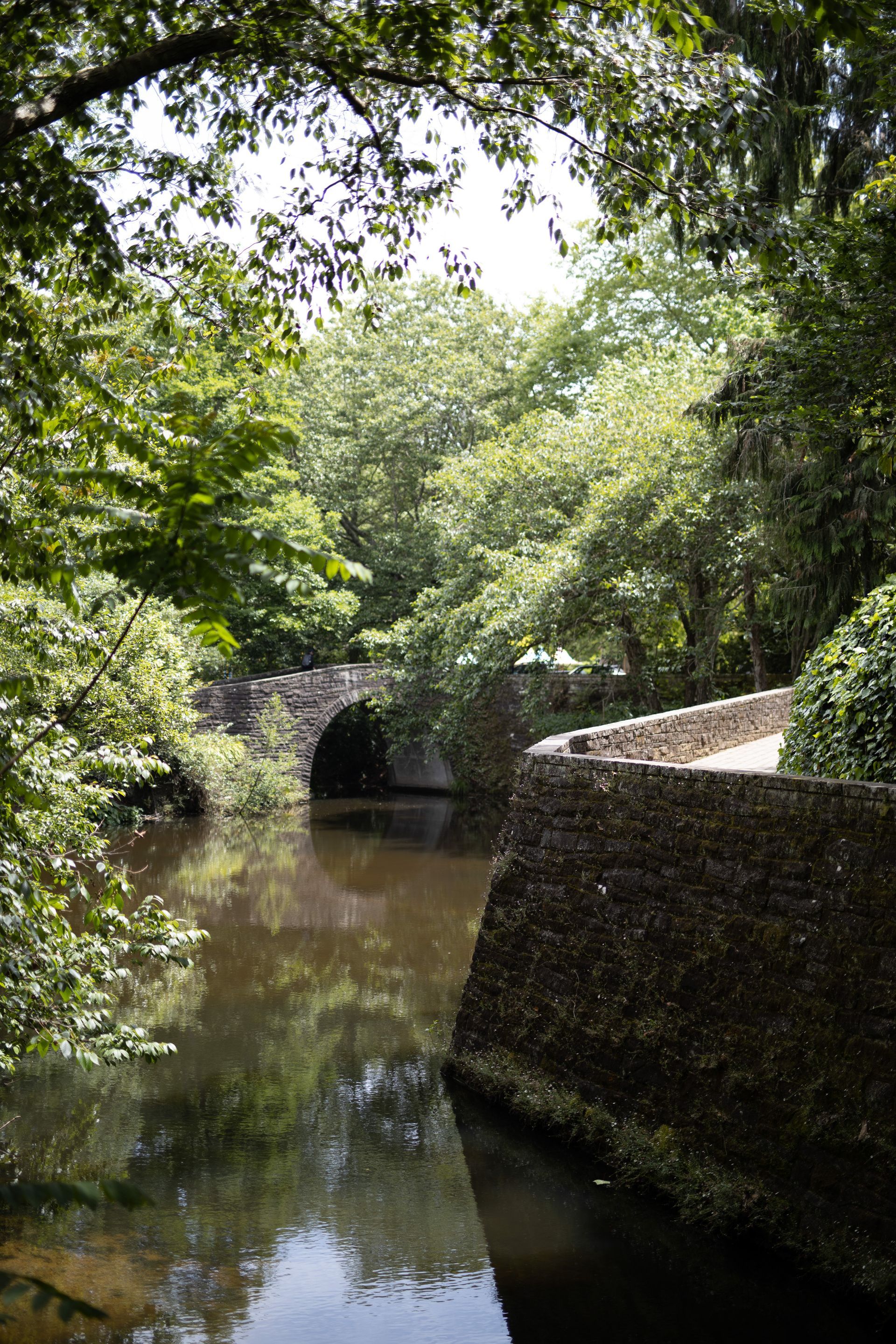 A stone bridge over a river surrounded by trees
