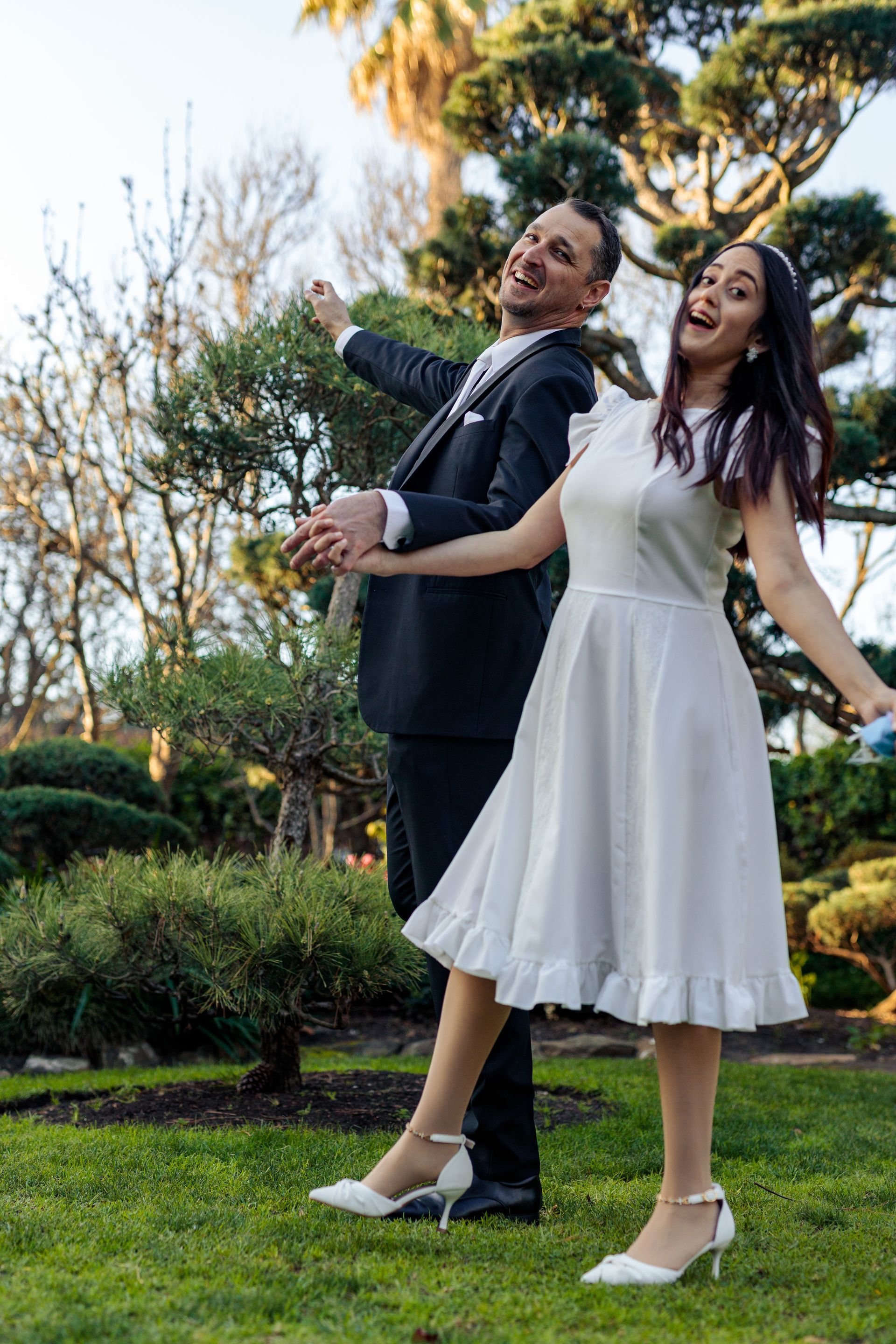 A bride and groom are posing for a picture in a park.