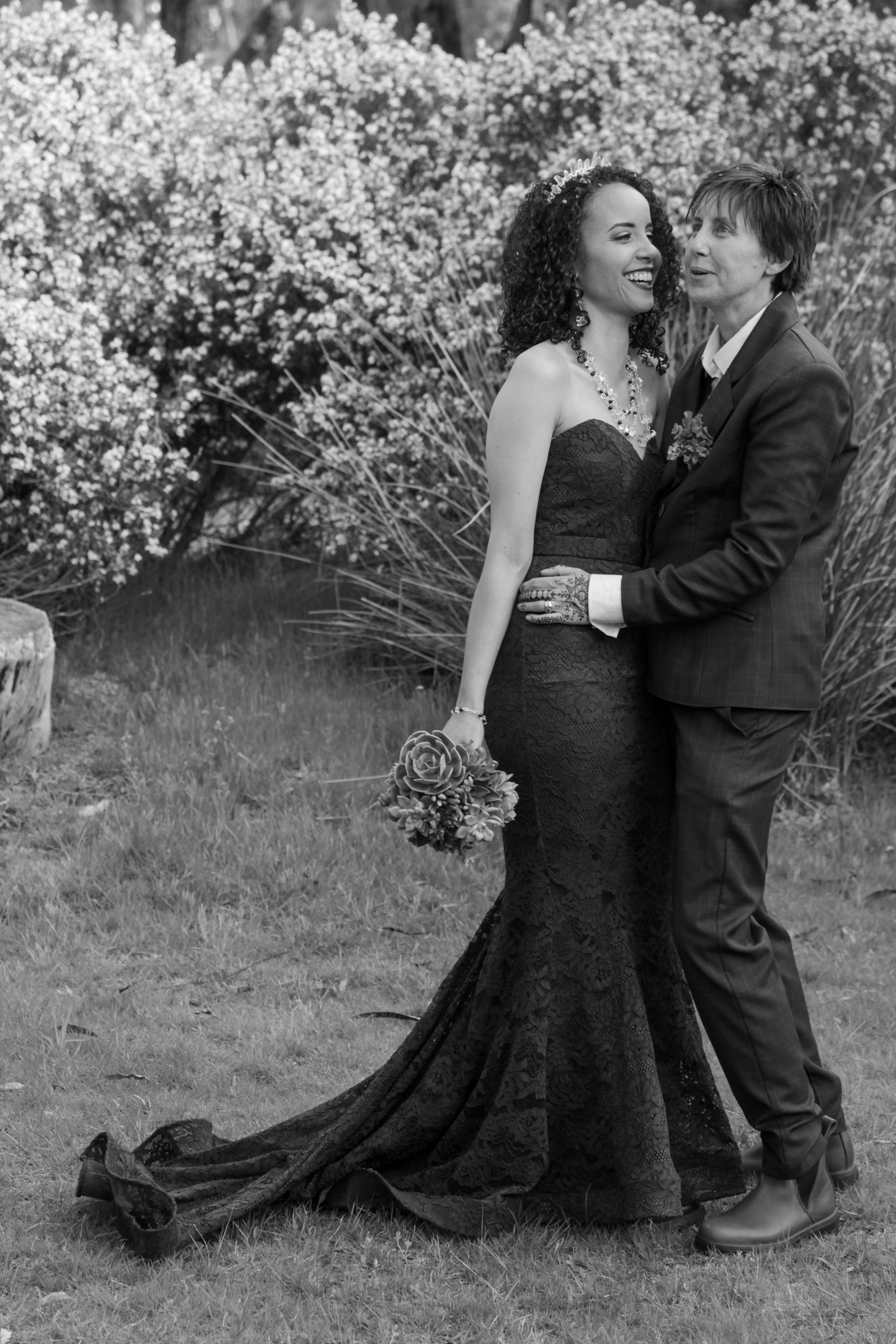 A woman in a black dress is standing next to a man in a suit.