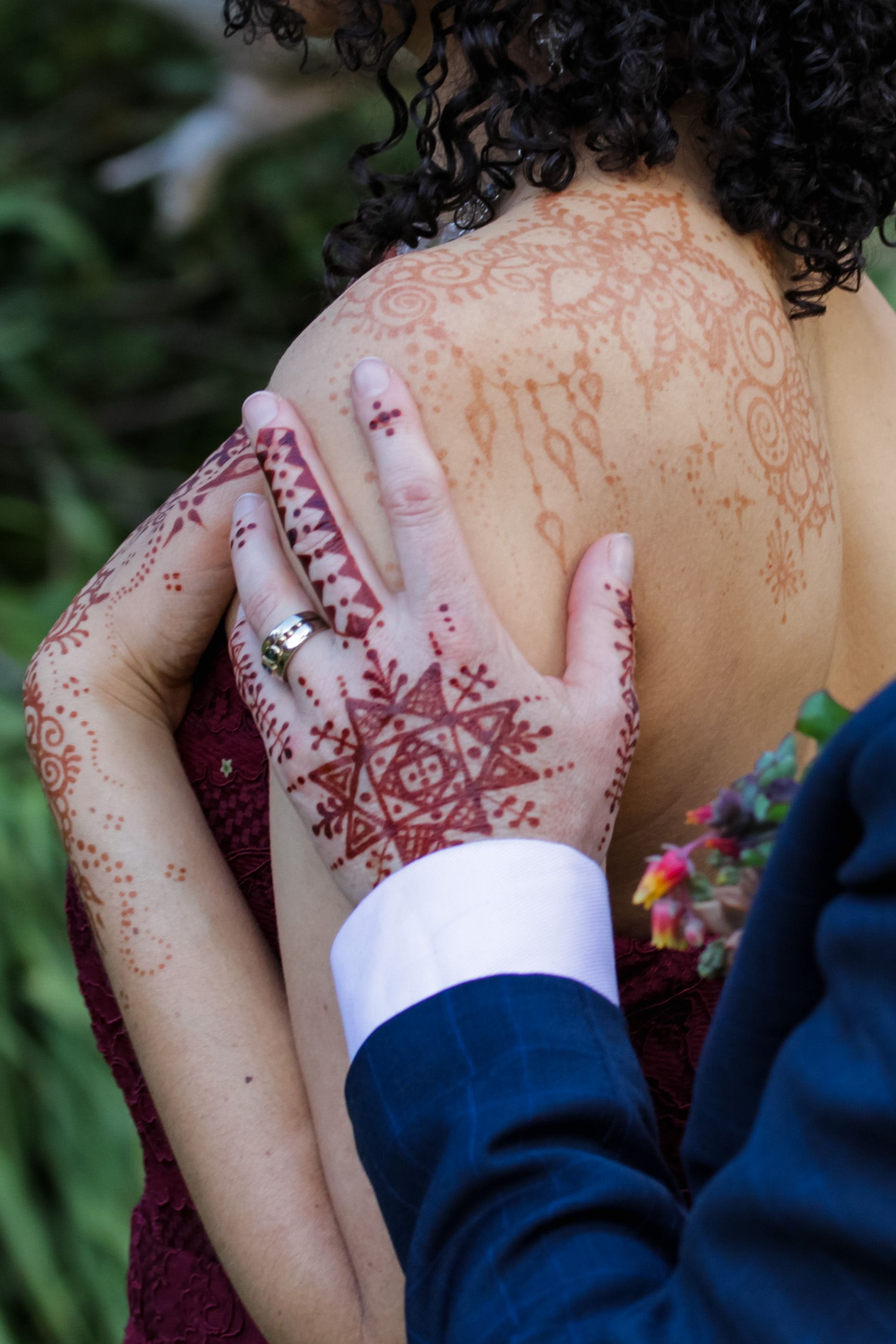 A man is touching a woman 's back with a ring on his finger.