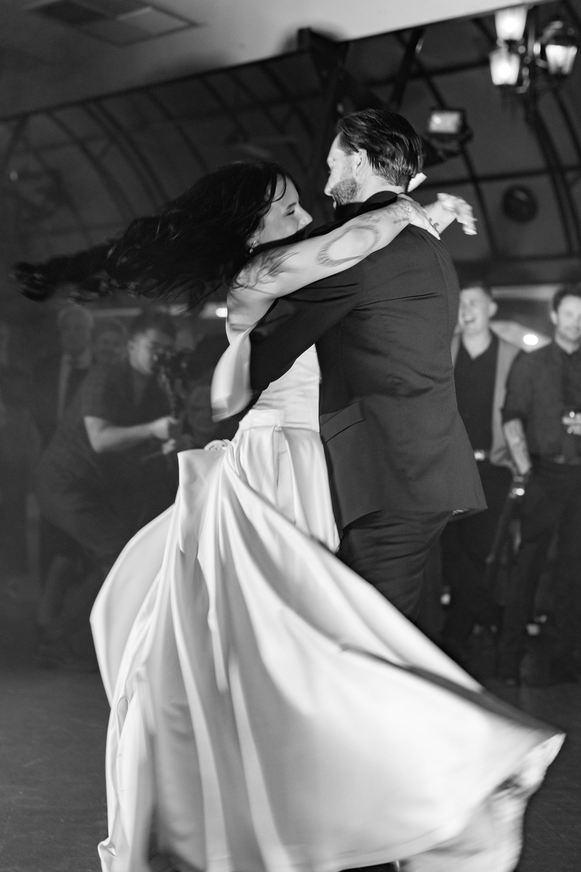 A black and white photo of a bride and groom dancing