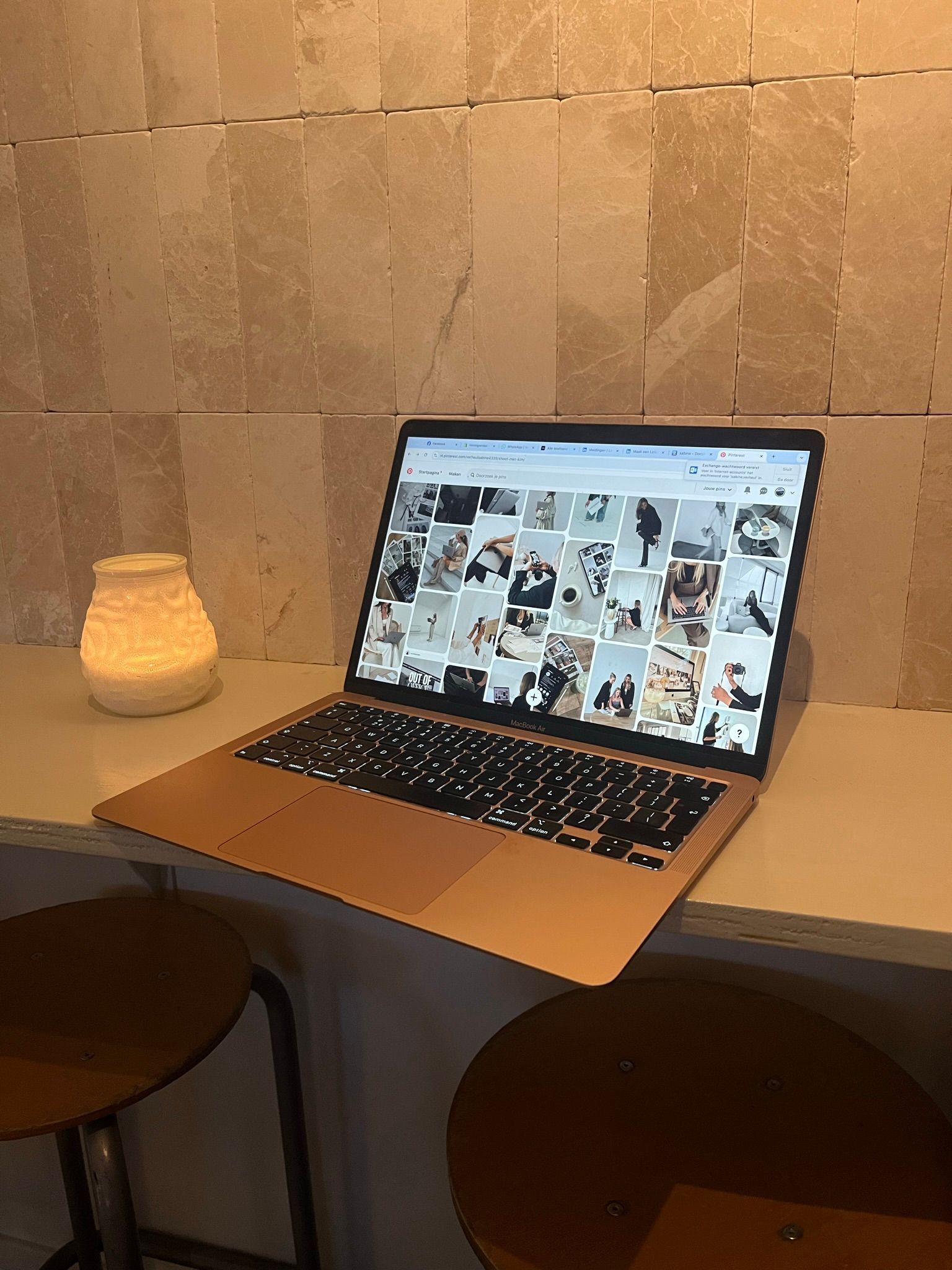 Er staat een laptop op een tafel naast een lamp.