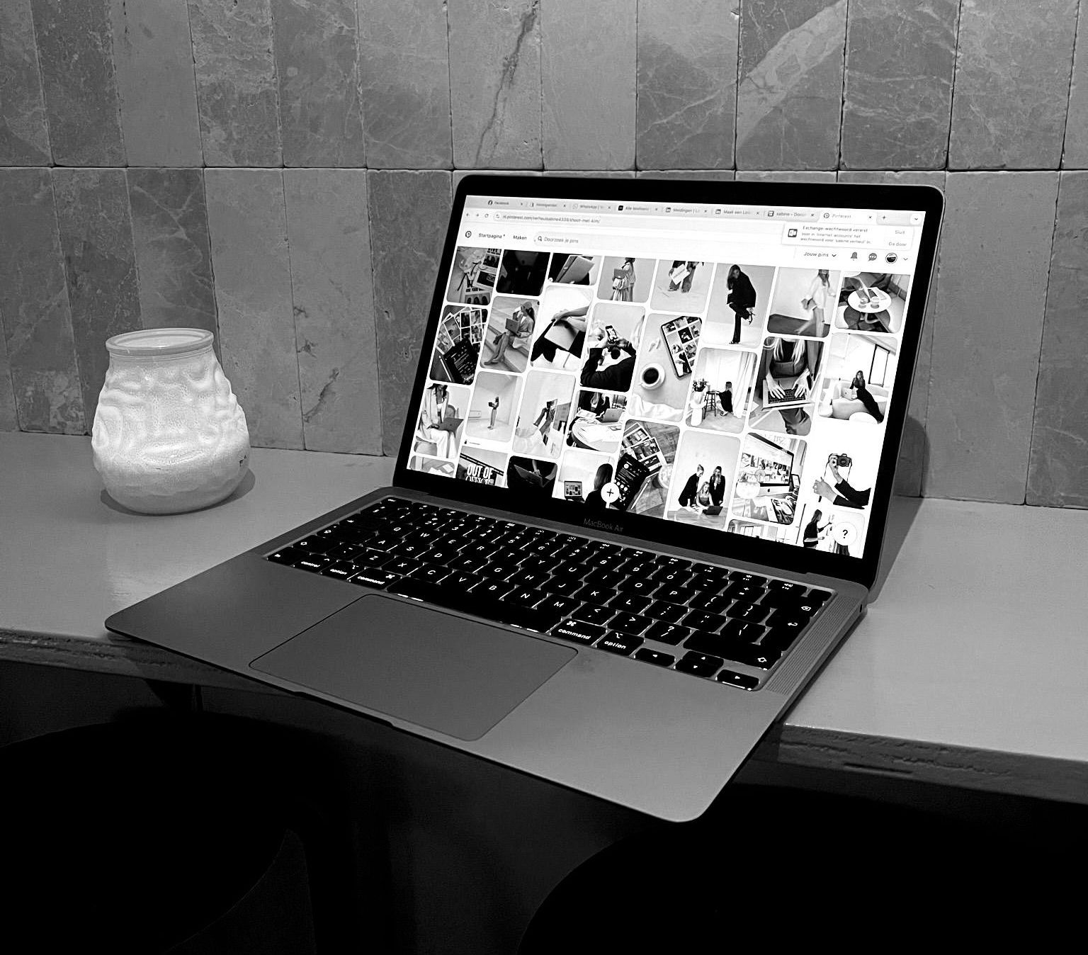 Een zwart-witfoto van een laptop op een tafel