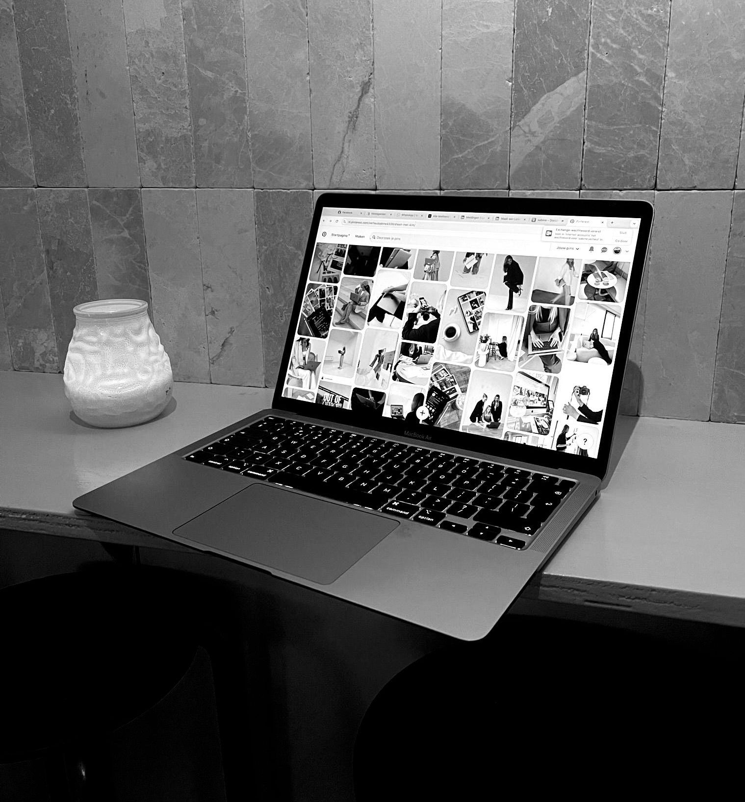Een zwart-witfoto van een laptop op een tafel