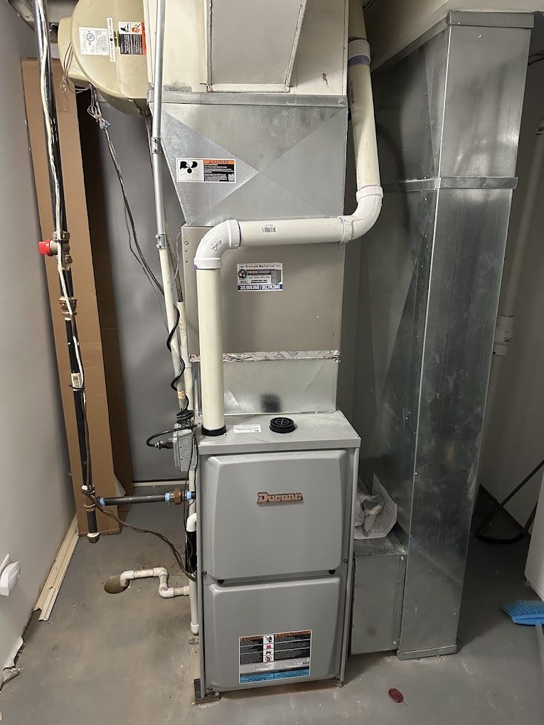 A furnace is sitting in a room next to a wall.