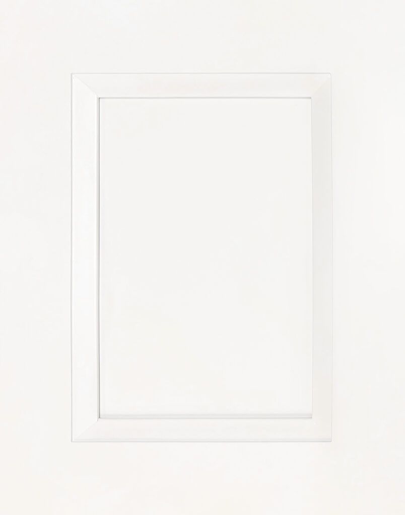 A white picture frame is hanging on a white wall.