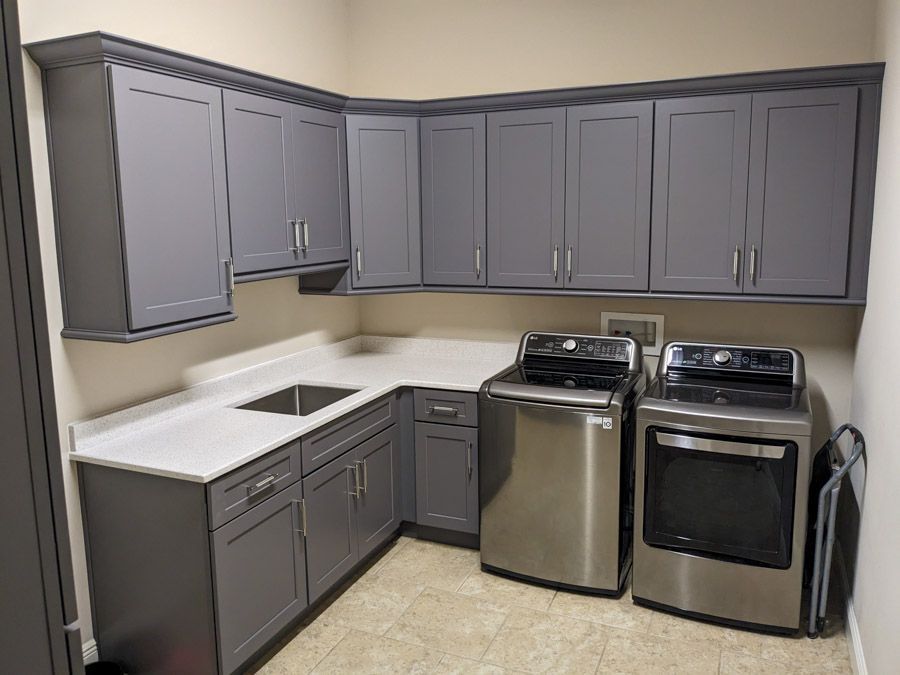 A kitchen with gray cabinets and stainless steel appliances.