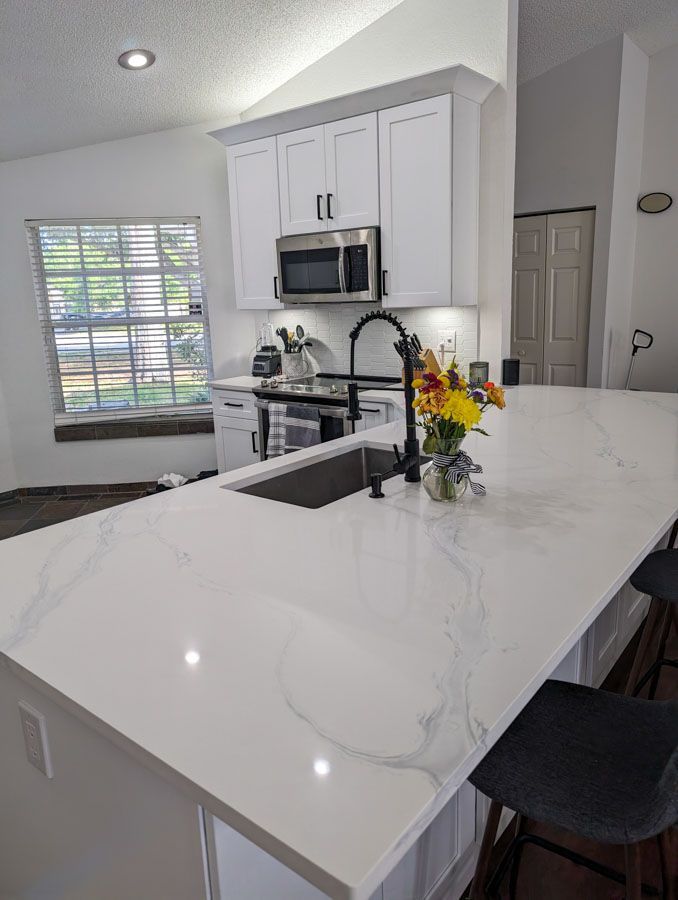 A kitchen with white cabinets and stainless steel appliances.