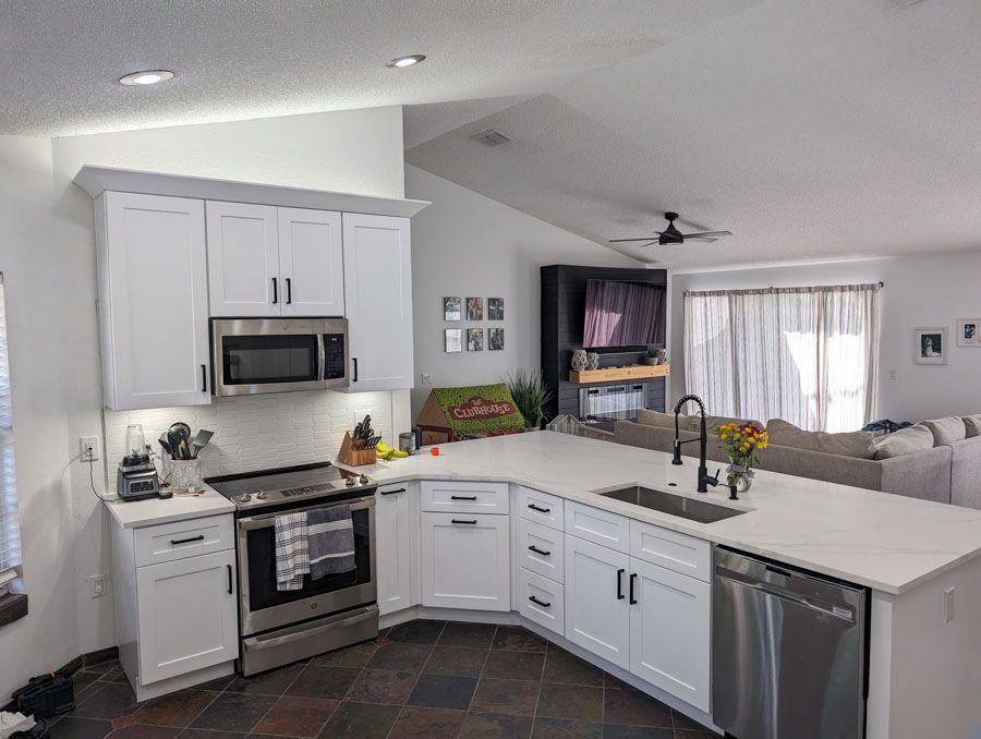 A kitchen with white cabinets and stainless steel appliances.